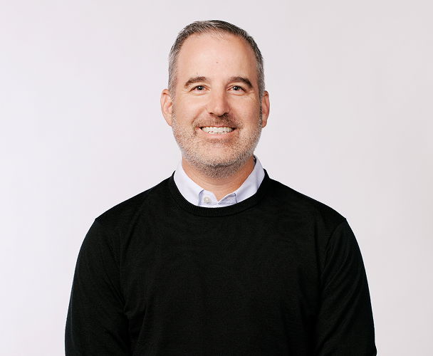 Headshot of Mike Wolff, Chief Revenue Officer, wearing a black sweater with a white collar visible.